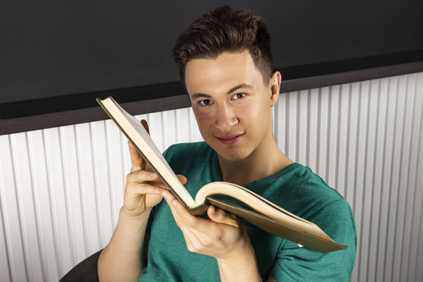Portrait of attractive young businessman reading at workplace. Education concept - Fotó, kép
