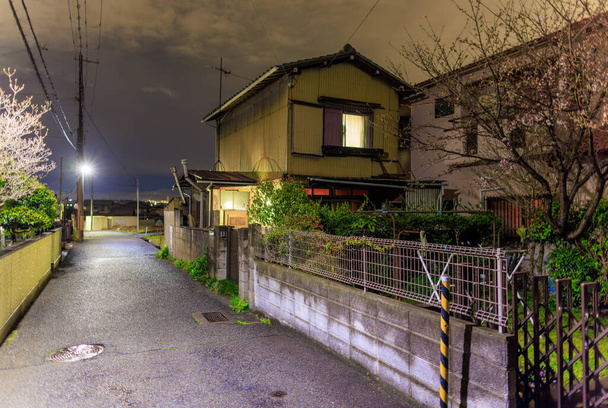 Sessiz caddedeki Japon evindeki ışıklar geceleri yerleşim yerlerinde yanar. Yüksek kalite fotoğraf - Fotoğraf, Görsel