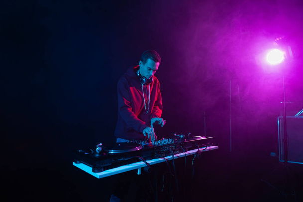 Profesionální DJ míchání vinylových desek na hip hop párty. Bílý muž hraje hudbu v nočním klubu - Fotografie, Obrázek