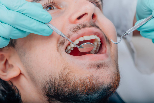 рот пациента с инструментами стоматолога - Фото, изображение