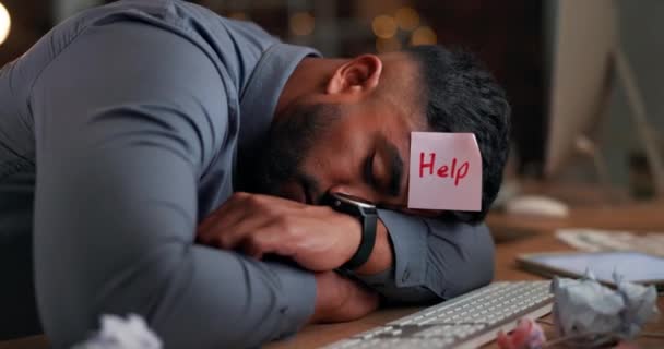 Άνθρωπος, νύχτα και κοιμάται στο γραφείο στο γραφείο με κούραση, κουρασμένος και υπόλοιπο με κολλώδη σημείωση στο κεφάλι για βοήθεια. Επιχειρηματίας, ύπνου και χαρτί στο μέτωπο στο τραπέζι με burnout, ψυχική υγεία και υπερκόπωση. - Πλάνα, βίντεο