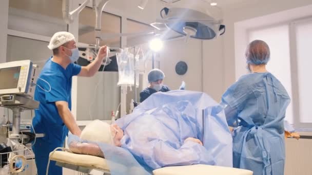 Chirurgen opereren op de benen van een oudere vrouw met spataderen. Het arbeidsproces van chirurgen - Video