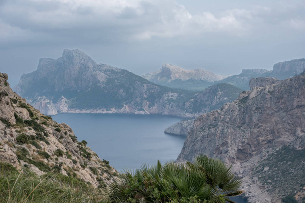Mallorca zord partvonalának felfedezése ködös hegyekkel és felhős égbolttal Spanyolországban - Fotó, kép