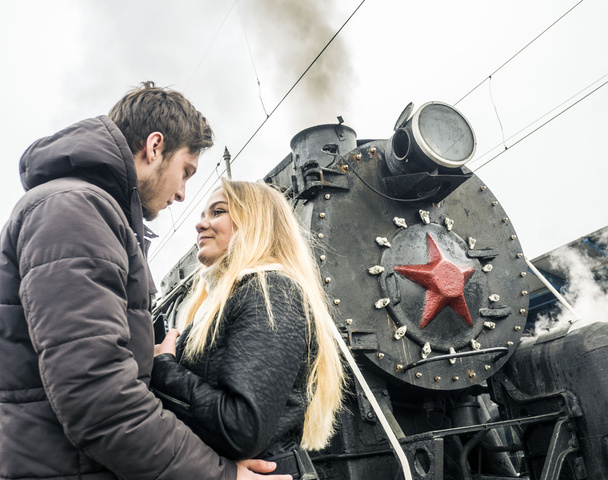 Couple kissing near old steam locomotive - Фото, зображення