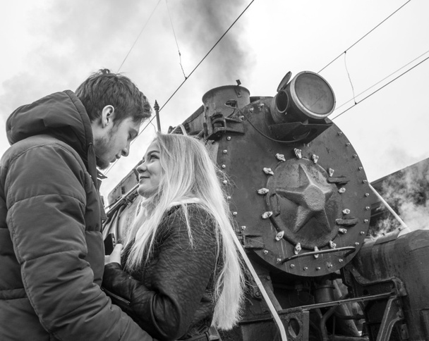 Couple kissing near old steam locomotive - Фото, зображення