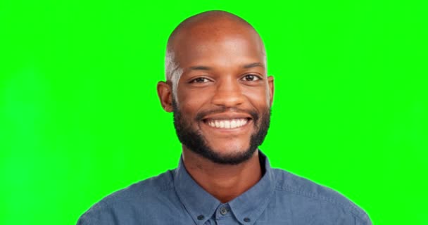 Gezicht, glimlach en een zwarte man op een groene scherm achtergrond in de studio op zoek naar zorgeloos of positief. Portret, knipoog en blij met een kale man op chromakey mockup gevoel vrolijk over product plaatsing. - Video