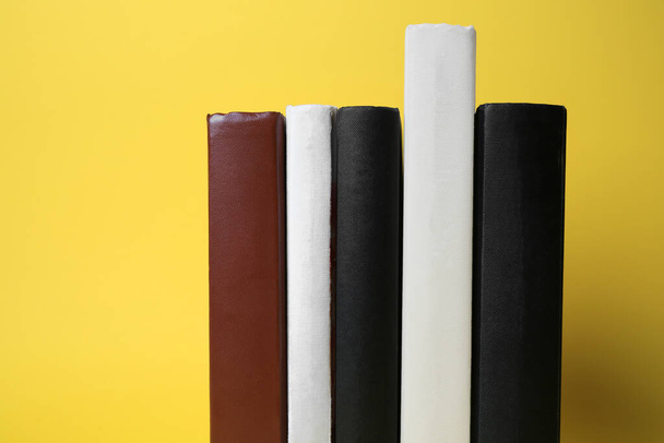 Collection of hardcover books on yellow background, space for text - Fotó, kép