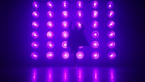 Stylish dancer in trendy outfit performing at concert in Night Club. Night lifestyle, party concept shot. Silhouette of professional RnB dance performer moving hips at bright colorful strobing lights - Footage, Video