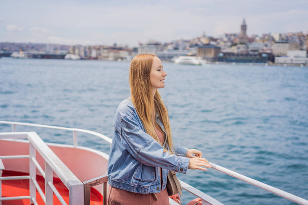 Happy woman enjoying the sea from ferry boat crossing Bosphorus in Istanbul. Summer trip to Istanbul. - Фото, зображення