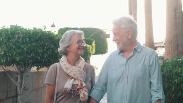 felvétel gyönyörű romantikus idős pár séta a város utcáin naplementekor - Felvétel, videó
