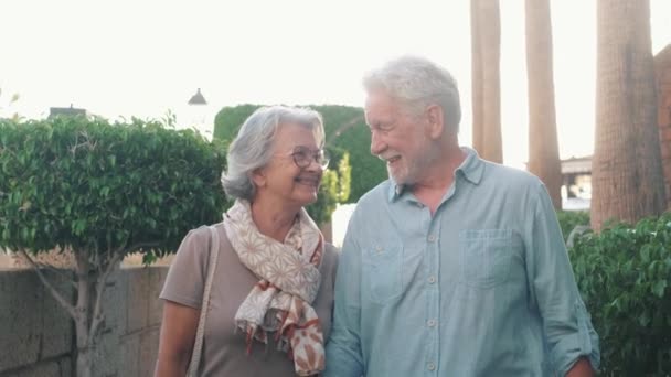 πλάνα από όμορφο ρομαντικό ζευγάρι ηλικιωμένων περπάτημα στο δρόμο της πόλης κατά τη διάρκεια του ηλιοβασιλέματος - Πλάνα, βίντεο