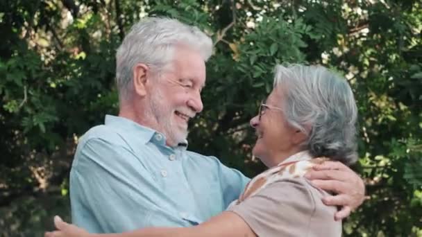 felvétel gyönyörű romantikus idős pár ölelkeznek a parkban naplementekor - Felvétel, videó