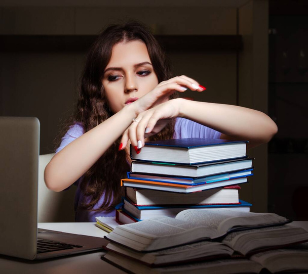 De jonge vrouwelijke student bereidt zich voor op examens laat thuis - Foto, afbeelding