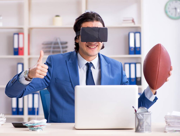 The young handsome businessman playing rugby with virtual glasses - Foto, afbeelding