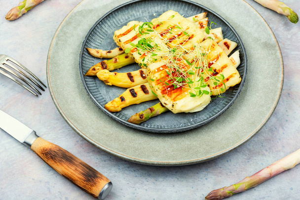 Delicious dish of baked white asparagus, halloumi cheese decorated with microgreens. - Photo, Image