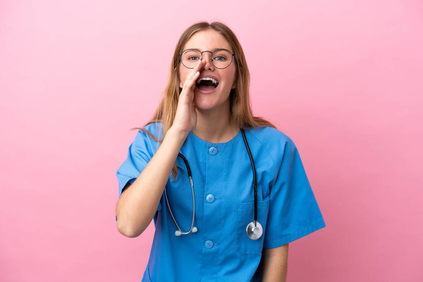 Nuori kirurgi lääkäri nainen eristetty vaaleanpunainen tausta huutaa suu auki - Valokuva, kuva