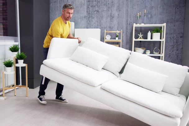 Verhuizen van nieuwe sofa meubels. Staande met bank - Foto, afbeelding