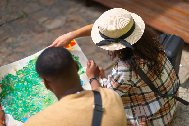 A lovely girlfriend is pointing on the map to help her confused boyfriend finding the destination - 写真・画像