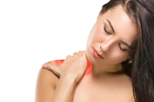 Brunette woman massaging her shoulder - Foto, afbeelding
