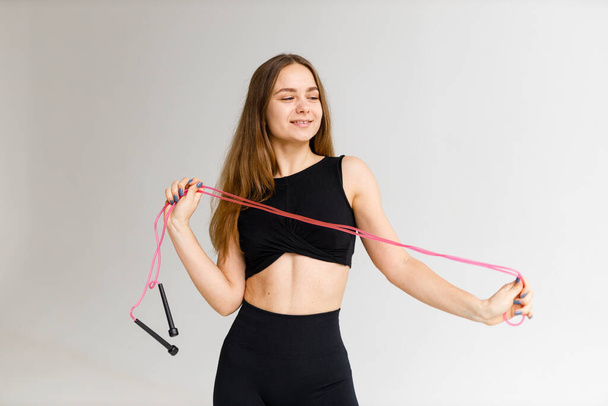 Endurance training, young natural woman holding a skipping rope in her hands. - Fotografie, Obrázek