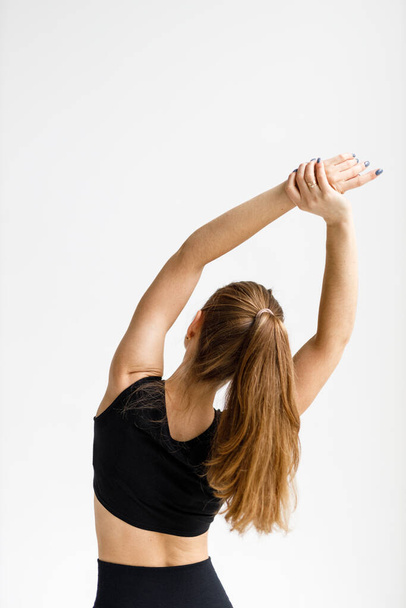 Exercises to warm up the back, the woman raised her hands up, view from the back. - Zdjęcie, obraz