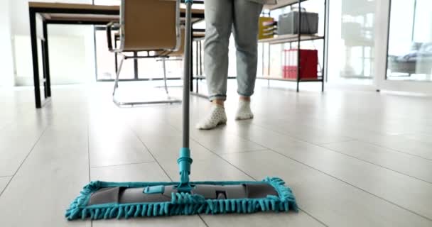 Schoonmaakster dweilen vloer met microvezel doek in kantoor closeup 4k film slow motion. Concept schoonmaakdiensten - Video