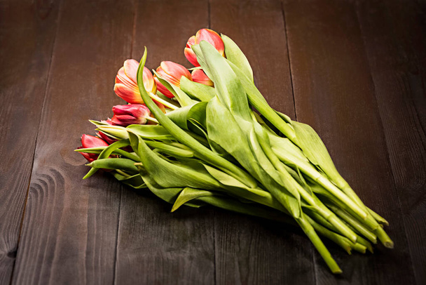 ouquet of tulips in a vase on a background of wooden boards - Valokuva, kuva