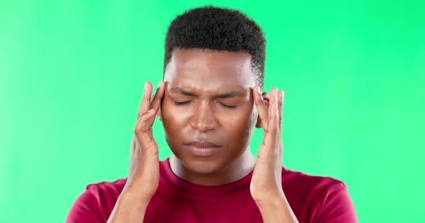Головная боль, стресс и черный мужчина с болью на зеленом экране в студии изолированы на заднем плане. Депрессия, психическое здоровье и африканский человек с тревогой, усталость или истощение, мигрень, болезнь или усталость - Кадры, видео