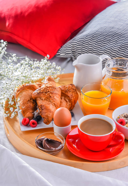 A tray with breakfast on a bed in a hotel room. - Photo, Image