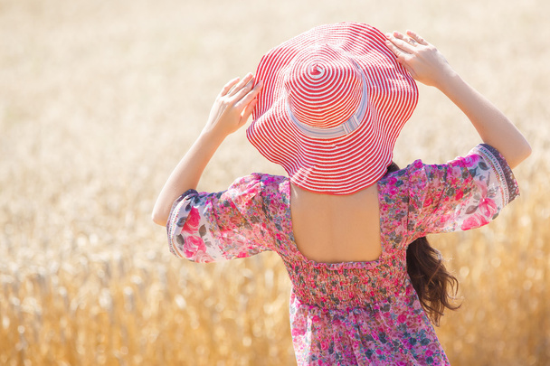 girl in hat on wheat field - 写真・画像