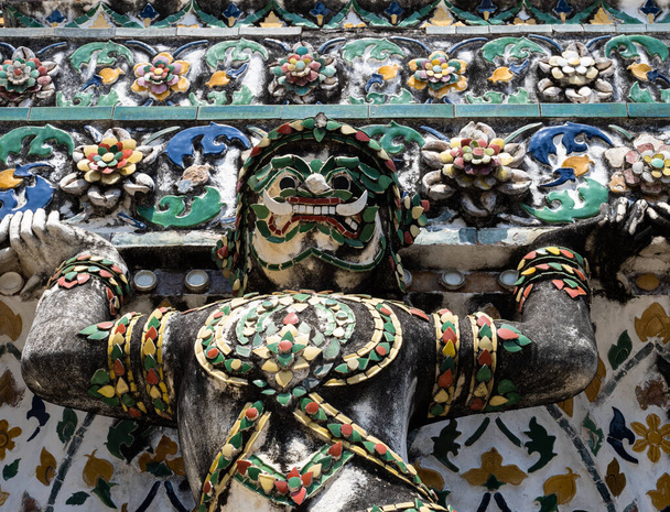 Voyez les détails exquis d'une statue décorative et colorée sur la façade de Wat Arun, le temple de l'aube, à Bangkok, en Thaïlande. Émerveillez-vous devant sa complexité et son dynamisme, qui témoignent des traditions artistiques et spirituelles de la re - Photo, image