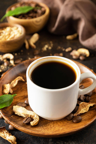 Здоровий органічний енергетичний адаптоген. Грибна кава в чашці та кавових зернах, модний напій на кам'яному фоні
.  - Фото, зображення