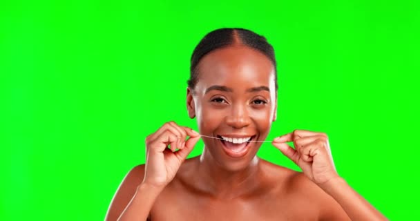 Face, dental floss and woman against green screen for teeth, cleaning and hygiene on studio background space. Oral, portrait and happy girl flossing for fresh, clean and breath, routine or prevention. - Footage, Video