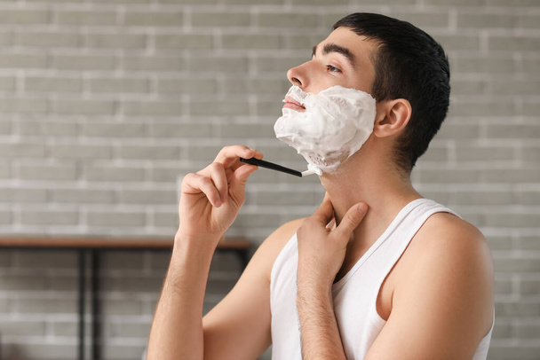 Young man shaving in bathroom - Photo, Image