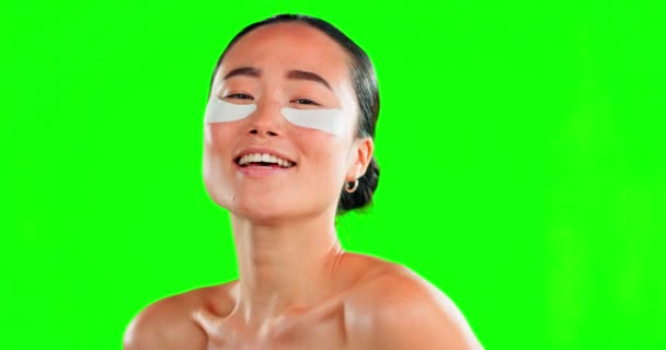 Face, skincare and Asian woman with eye patches on green screen in studio isolated on a background. Dermatology portrait, beauty cosmetics and happy female model with facial mask for healthy skin - Video, Çekim