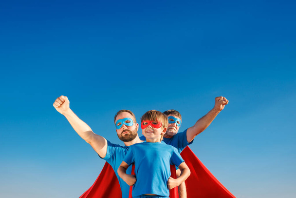 Senior, man and child outdoor against summer blue sky. Grandfather, father and son pretend to be superheroes. People having fun together. Family holiday concept. Happy Father's day - Zdjęcie, obraz