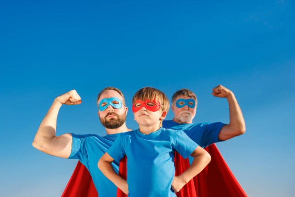 Senior, man and child outdoor against summer blue sky. Grandfather, father and son pretend to be superheroes. People having fun together. Family holiday concept. Happy Father's day - Foto, Imagen