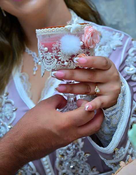 Nahaufnahme der Hände eines marokkanischen Paares bei einer Hochzeit, Konzept der Ehe, marokkanische Hochzeit - Foto, Bild