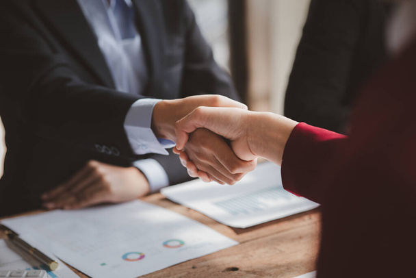 Üzleti befektetői csoport kézfogás, két üzletember megállapodik az üzletben, és kezet fognak egy sikeres tárgyalás után. A kézfogás egy nyugati üdvözlés vagy gratuláció.. - Fotó, kép