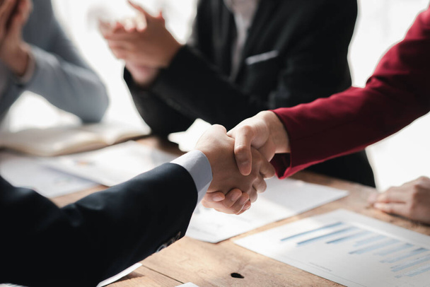 Business investor group handshake, Two businessmen are agreeing on business together and shaking hands after a successful negotiation. Handshaking is a Western greeting or congratulation. - Foto, afbeelding