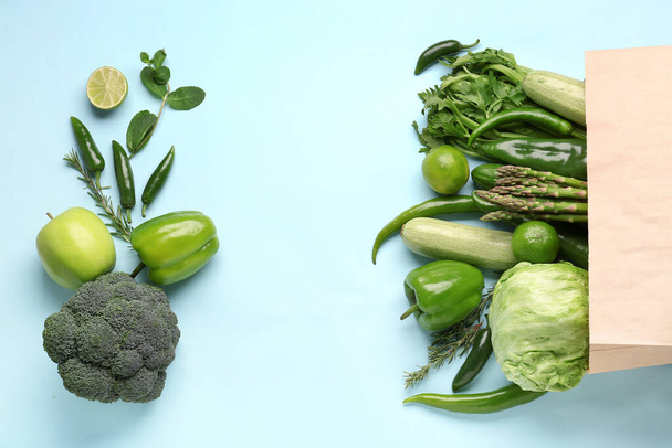 Composition avec différents légumes et fruits frais sur fond bleu - Photo, image