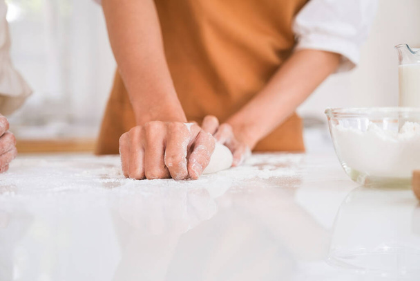 Woman kneading dough on the table. - 写真・画像