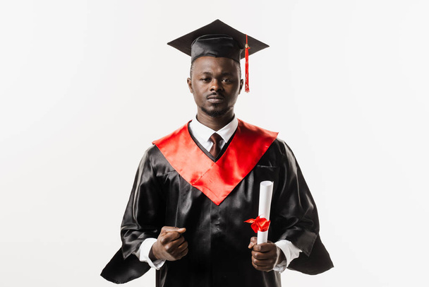 Graduate african man graduated from university and got master degree. Graduation. Happy african man smiling and holding diploma with honors in his hands on white background - Foto, imagen