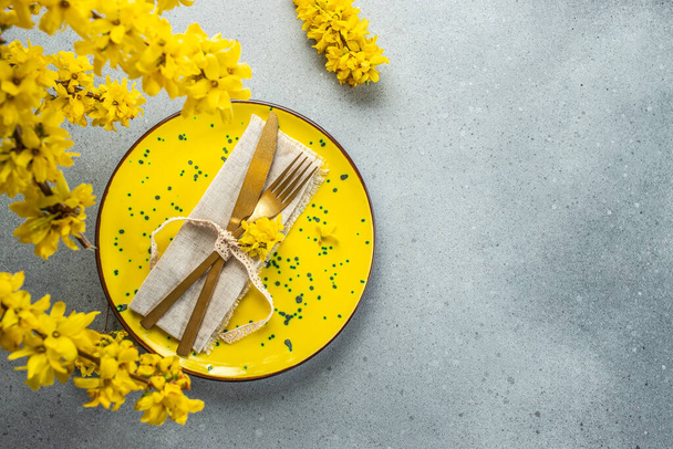 Osterbrunch Tischdecken. Serviette auf Teller mit Frühlingsblumen. Kartendesign, Ansicht von oben. - Foto, Bild