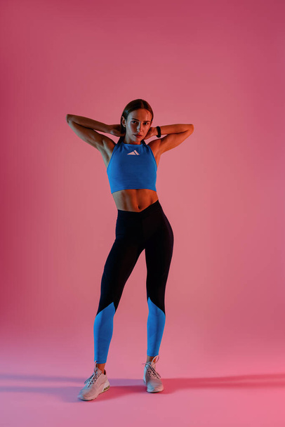 Beautiful fitness woman wearing sportswear posing over studio background. High quality photo - Zdjęcie, obraz