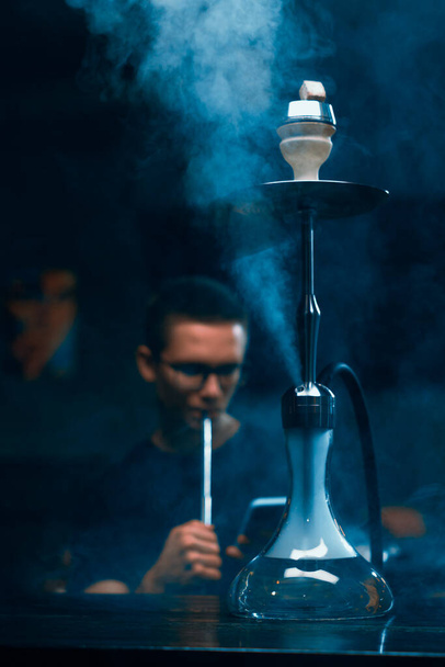 フカ男で眼鏡喫煙A伝統的なフカパイプ男exhaling煙でフカカフェまたはラウンジバー - 写真・画像
