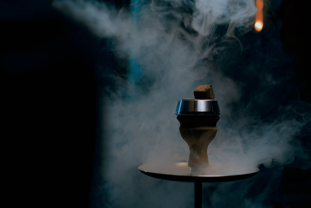 gros plan de bol narguilé avec des charbons brûlants en fond de fumée dans le concept de tabagisme bar salon narguilé - Photo, image