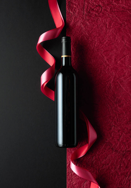 Bottle of red wine with red and pink satin ribbons. Top view. - Fotografie, Obrázek