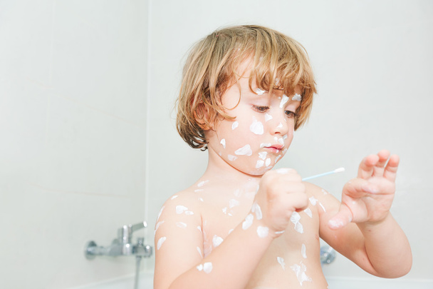 Adorable toddler boy putting cream on his body full of chicken pox - Photo, Image