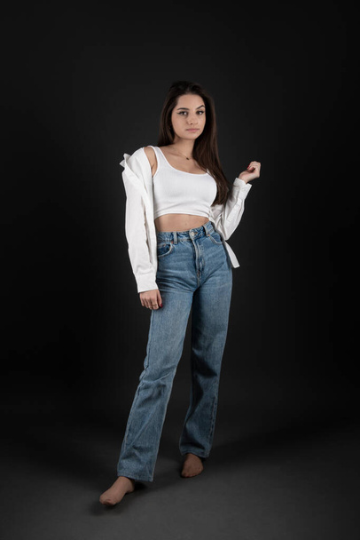 Молодая и красивая девушка-подросток в джинсах.
  - Фото, изображение